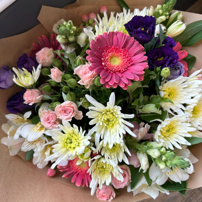 Petal Paradise - A lively bouquet featuring a bright mix of vibrant seasonal blooms. Complemented by lush green foliage and presented in a beautiful packaging, this arrangement is perfect for adding a pop of colour to any occasion